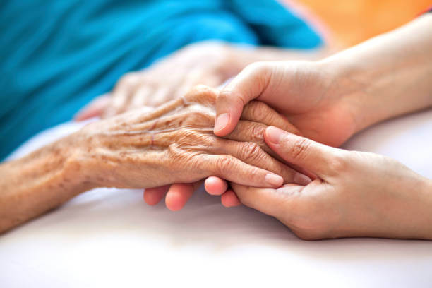Caregiver holding elderly hands